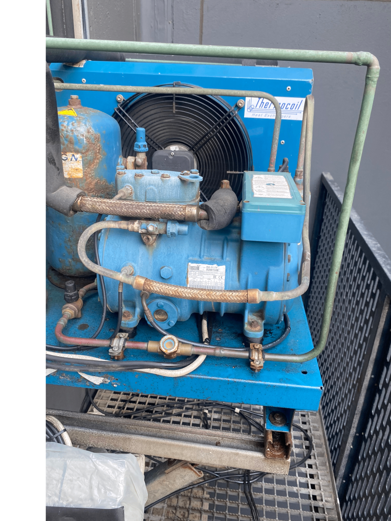 Servicing a blue commercial refrigeration unit
