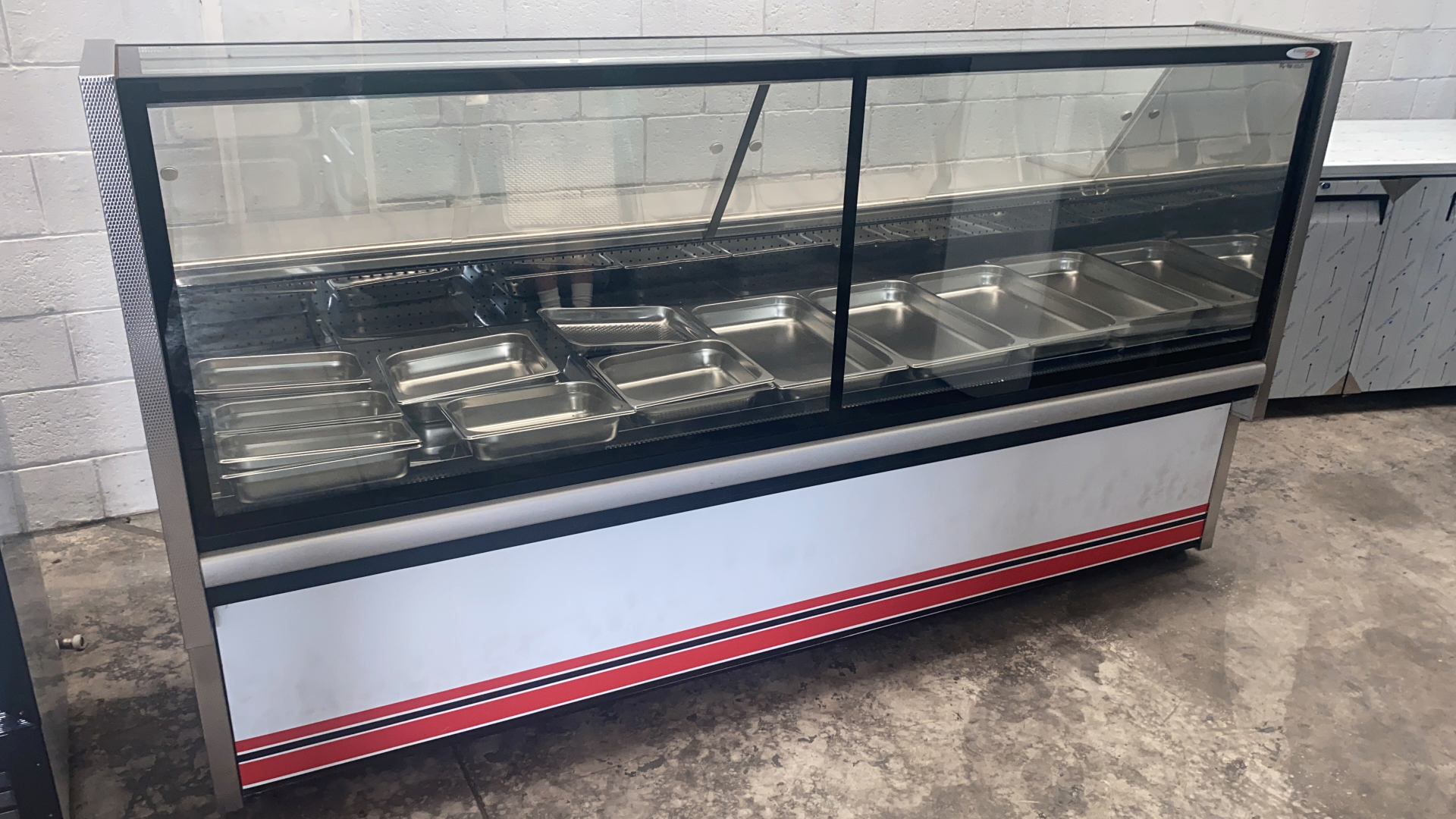 Large refrigerated display cabinet fitted with serving trays